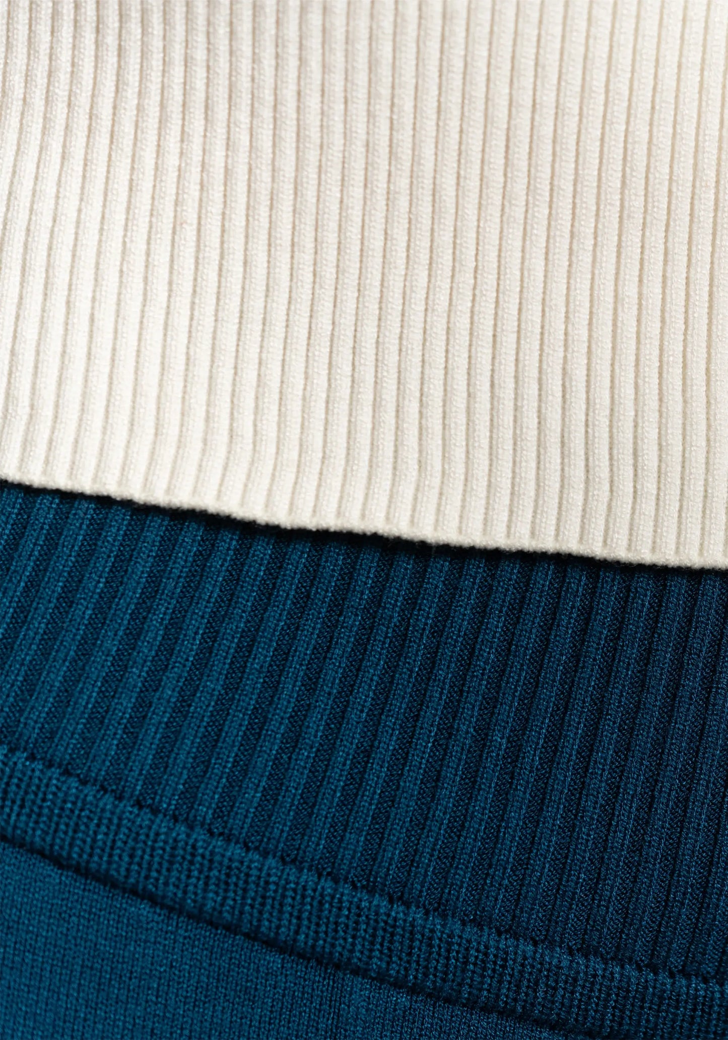 Texture close-up of the Women's Camille Ribbed Crop Top in ivory paired with ocean blue sweats showing the texture of the ribbed design