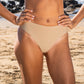 Lower half of woman in a tan bikini on the beach