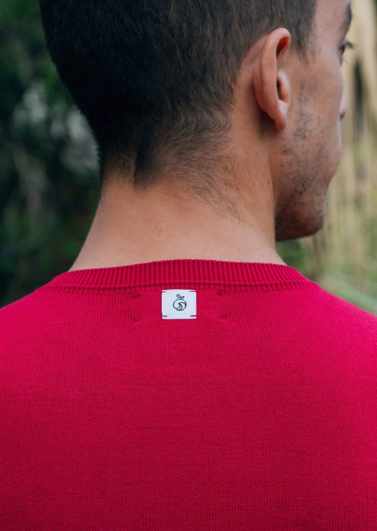 Back of Model showcasing the men's crew neck sweater in red