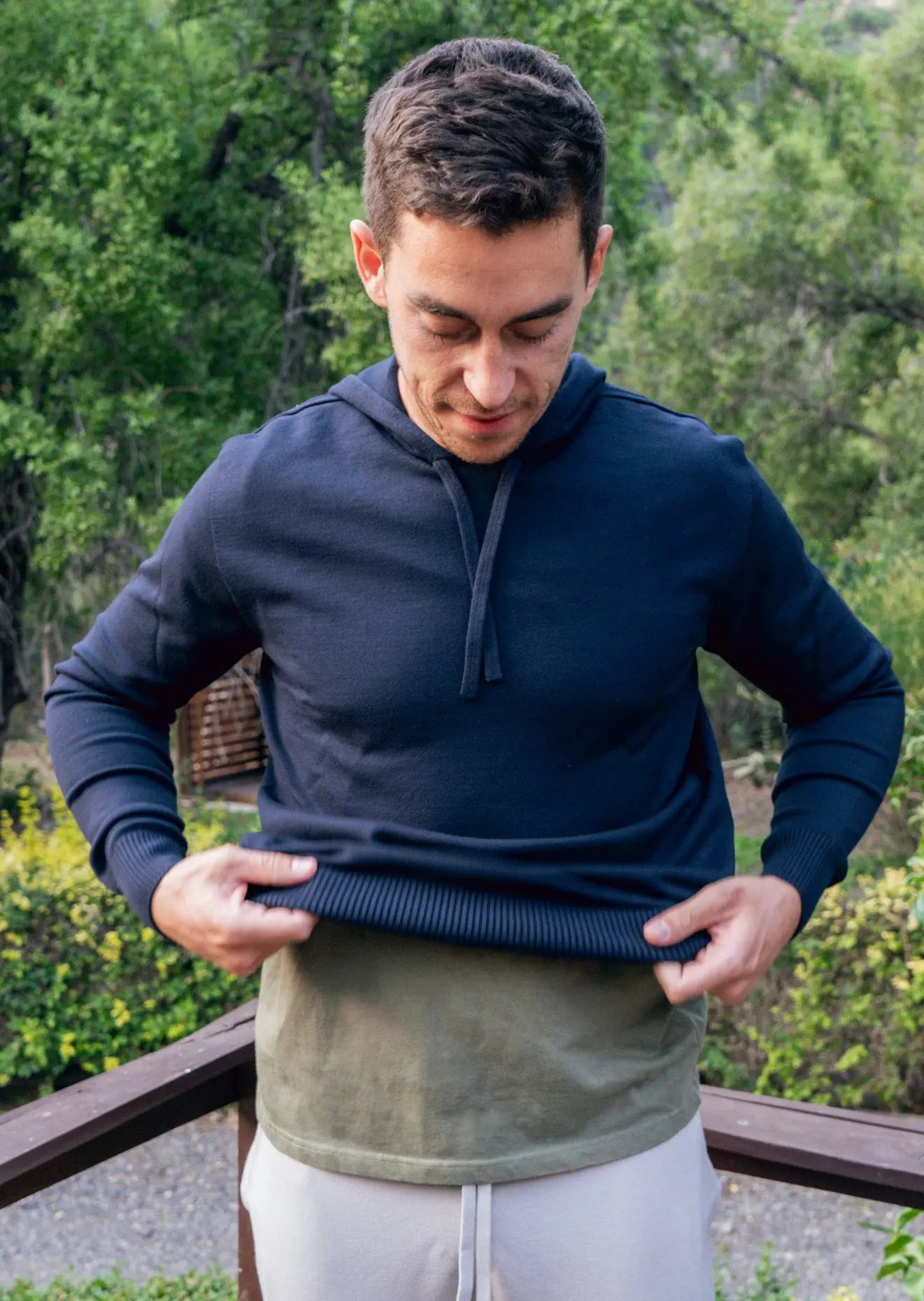 Male model wearing "Carter Classic" hoodie and sweatpants on a deck