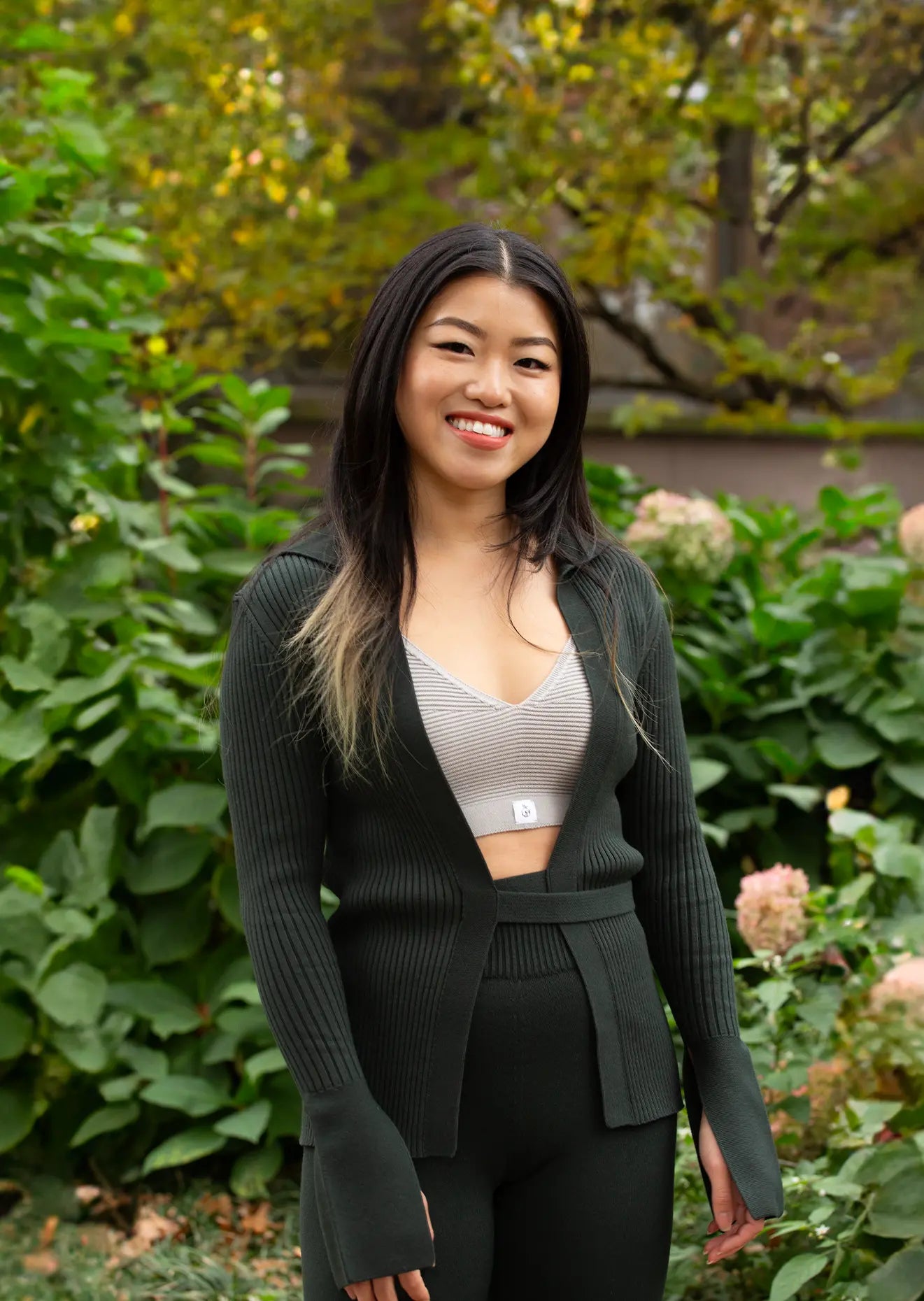 A woman posing in the Women's Delancey Wrap Sweater paired with matching no drawstring leggings