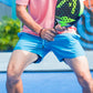 Men's Retro 5" Inseam Swim Trunks being held by a model with a tennis racket to suggest an active lifestyle