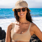 Model standing on the shore in the Women's Suzy Bikini Top in beige with a matching beach hat