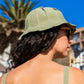 Side profile of a woman in front of a hotel with palm trees